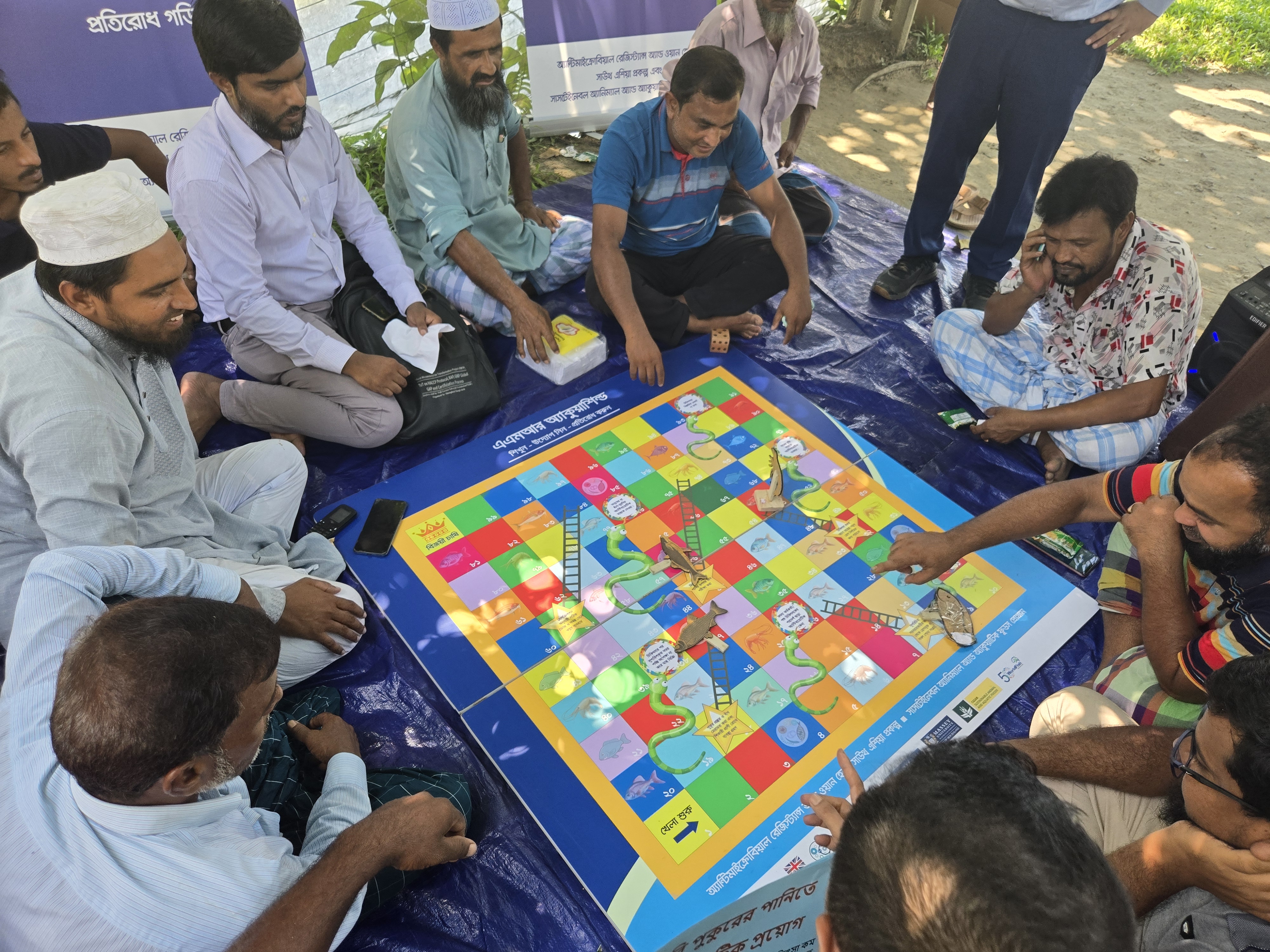 Participants playing AMR AquaShield Snakes and Ladders game to understand AMR risks in aquaculture. Photo: Sabrina Hossain/WorldFish