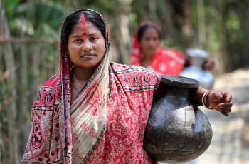 Komola Roy carrying drinking water in Fultola Village, Khulna, Bangladesh
