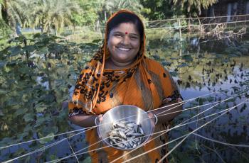Fish farmer Champa Debnath poses with Mola from her pond in the Khulna District of Bangladesh. Photo by Habibul Haque.
