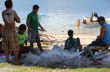 Fishermen mending fish net, Mancilang, Madridejos, Cebu, Philippines. Photo by Vianney Tumala.