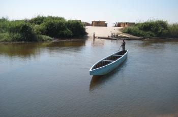 Young man paddling a boat used for transportation and other purposes, Zambia. Photo by Steven Cole.