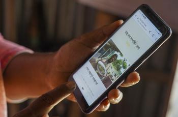 Mst. Shilpi Begum, a woman entrepreneur and fish farmer, is using The Right Hut web site on her mobile phone. Photo by worldFish.