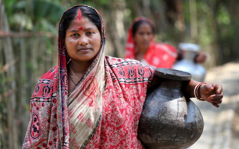 Komola Roy carrying drinking water in Fultola Village, Khulna, Bangladesh