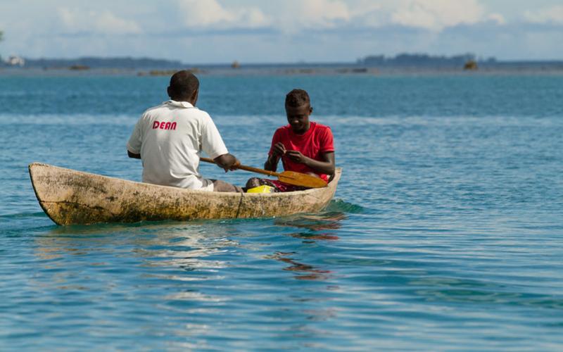 Men paddle out to reef to catch fish in the Solomon Islands. Photo by Filip Milovac. 