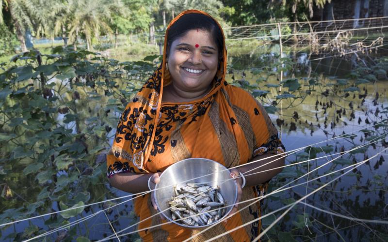 Fish farmer Champa Debnath poses with Mola from her pond in the Khulna District of Bangladesh. Photo by Habibul Haque.