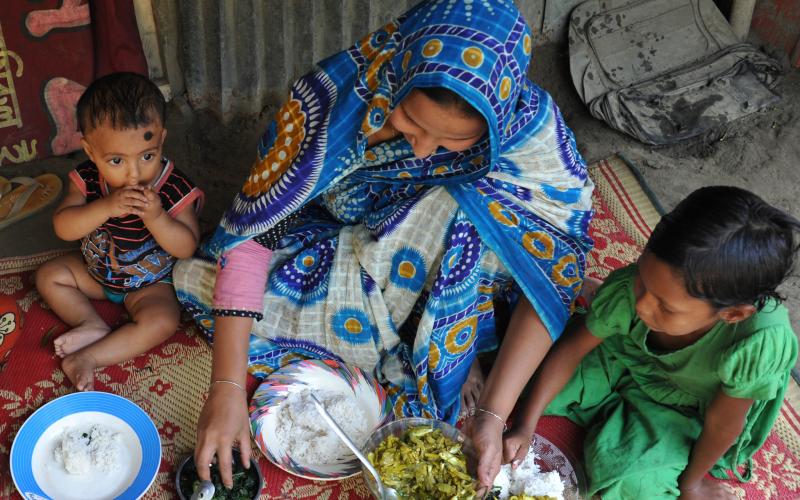 A Bangladeshi mother feeding her children nutrient-rich small fish and leafy vegetables. Photo by Finn Thilsted.