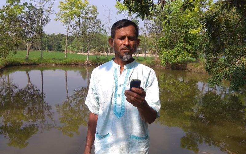 A fish farmer from Rangpur receiving weather forecast from Bangladesh Meteorological Department’s toll-free hot line number. Photo by Harun Or Rashid