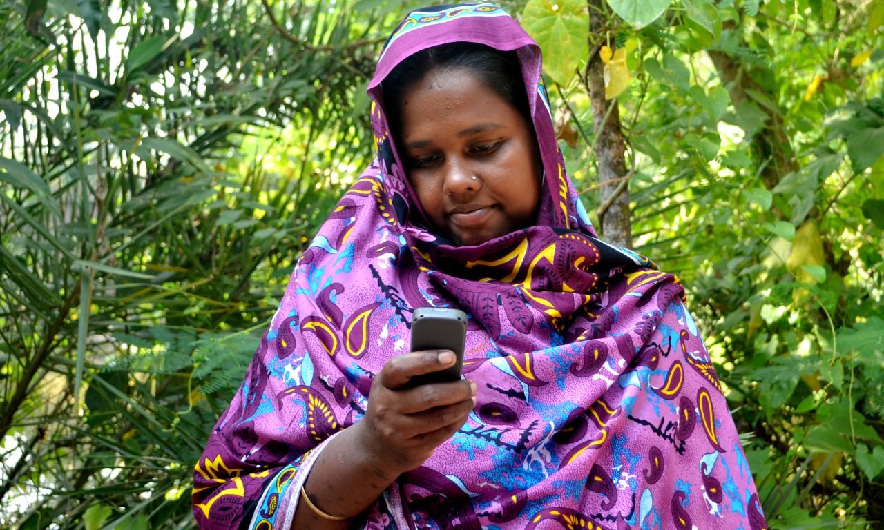 A Bangladeshi fisherwoman receives payment on her mobile phone. Photo by Sayma Islam.