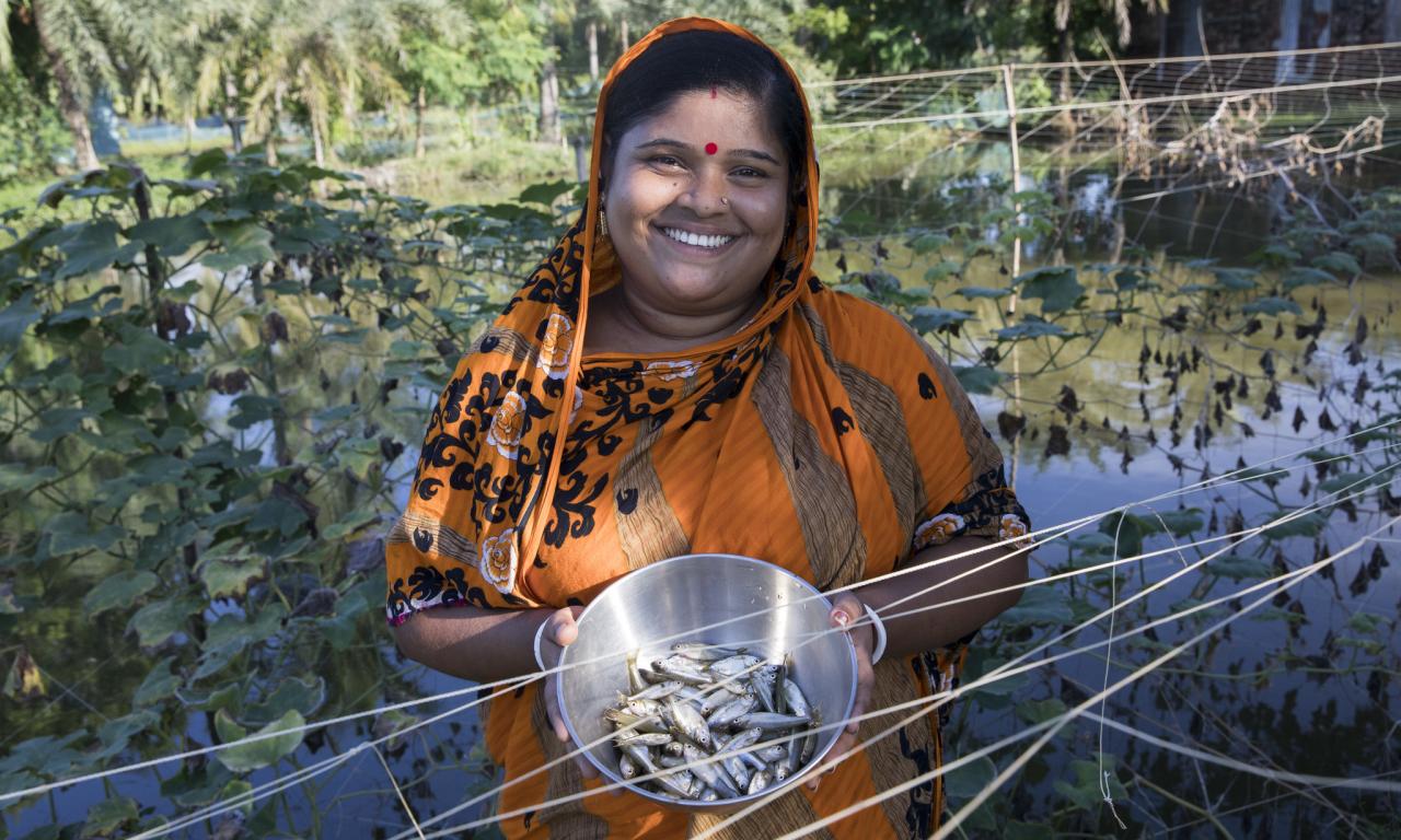 Fish farmer Champa Debnath poses with Mola from her pond in the Khulna District of Bangladesh. Photo by Habibul Haque.