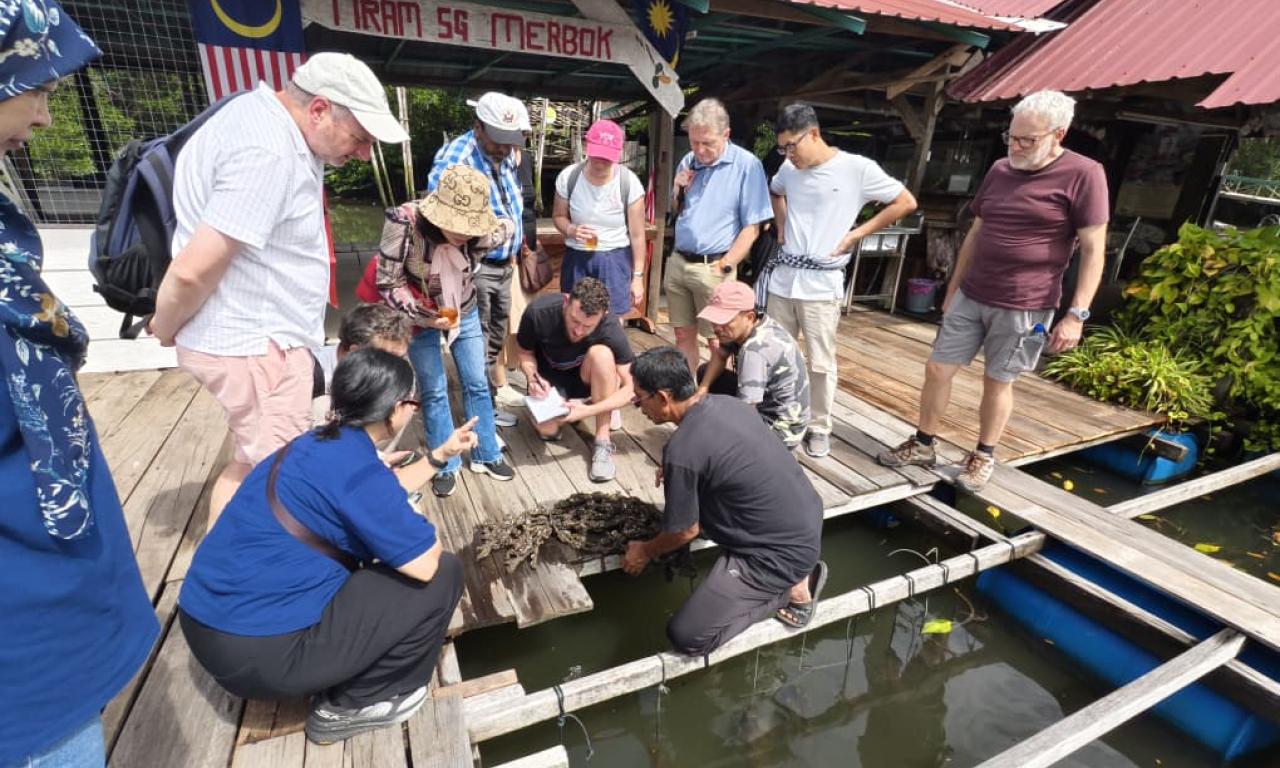 WAVES project partners during a field visit to the Sungai Merbok oyster farm, discussing farming practices and industry challenges with local producers.